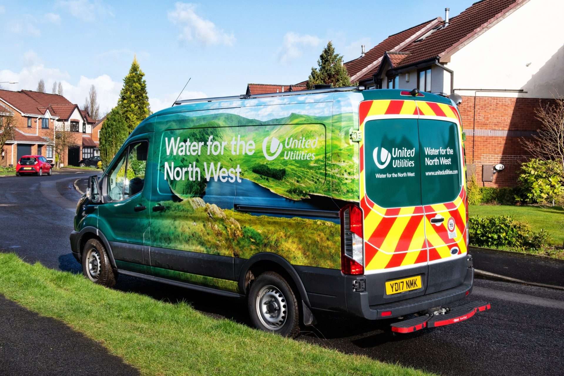 United Utilities van with a green hillside wrap parked on a residential street.